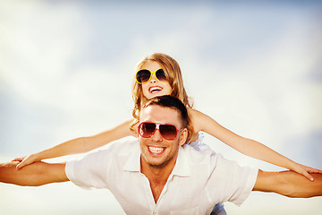 Image showing happy father and child in sunglasses over blue sky