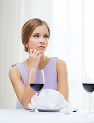 Image showing upset woman with glass of whine waiting for date