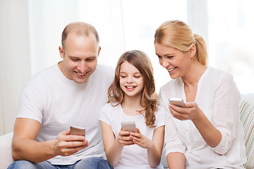 Image showing parents and little girl with smartphones at home