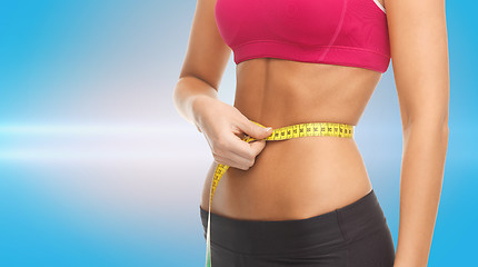 Image showing close up trained belly with measuring tape