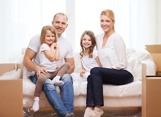 Image showing smiling parents and two little girls at new home