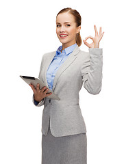 Image showing smiling woman looking at tablet pc computer