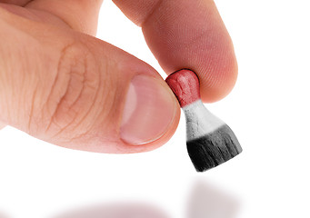 Image showing Hand holding wooden pawn, flag painting, selective focus