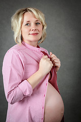 Image showing beautiful pregnant woman tenderly holding her tummy