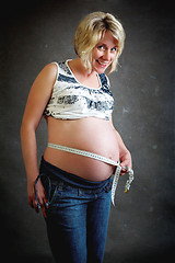 Image showing beautiful pregnant woman tenderly measuring her tummy