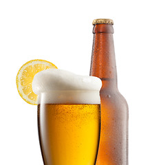 Image showing Beer in glass with lemon and bottle isolated on white