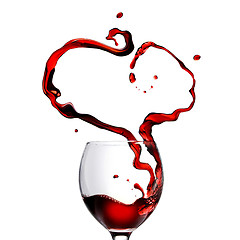 Image showing Heart made of pouring red wine in glass isolated on white