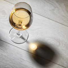 Image showing Glass of white wine on wooden table. Top view