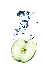 Image showing green apple dropped into water with bubbles isolated on white