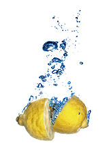 Image showing Fresh lemon dropped into water with bubbles isolated on white