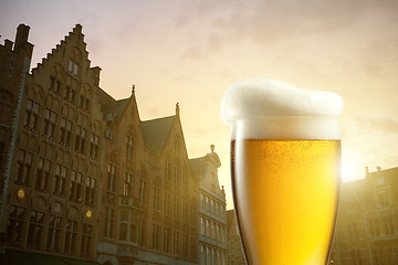 Image showing Glass of beer against silhouettes of houses in Bruges, Belgium