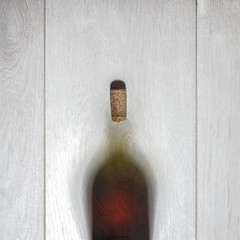 Image showing Bottle of red wine with cork on white wooden table. Top view