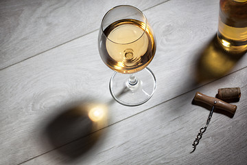 Image showing Glass of white wine on wooden table. Top view