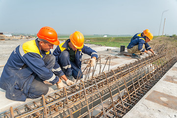 Image showing Workers mount bridge span