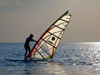Image showing A women is learning windsurfing at the sunset