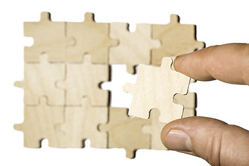 Image showing Wooden puzzle on white background. . Close up