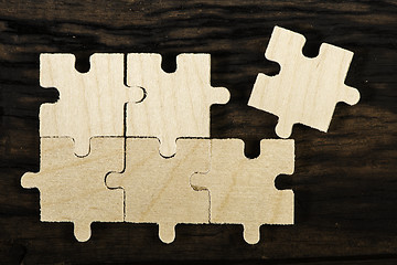 Image showing Wooden puzzle on dark background. 