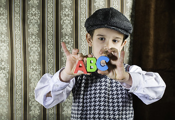 Image showing Child in vintage clothes hold letters a b c