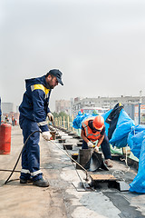 Image showing Workers make waterproofing of seams on the bridge