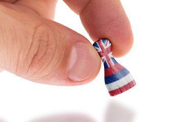 Image showing Hand holding wooden pawn, flag painting, selective focus