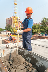 Image showing Worker kneads solution for bricklayers
