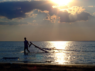 Image showing The guy drags the windsurf on a sunset