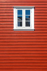 Image showing White wooden window on the red wooden house wall