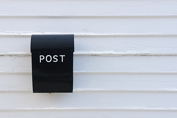 Image showing Black mail box on the traditional white wooden wall of house