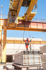 Image showing Slinger accepts plates at crane operator