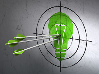 Image showing Finance concept: arrows in Light Bulb target on wall background