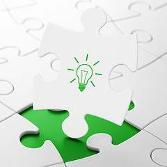 Image showing Finance concept: Light Bulb on puzzle background