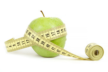 Image showing green apple with a measuring tape and heart symbol isolated