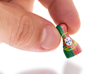 Image showing Hand holding wooden pawn, flag painting, selective focus