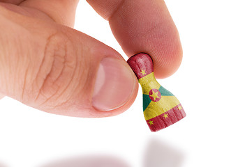 Image showing Hand holding wooden pawn, flag painting, selective focus