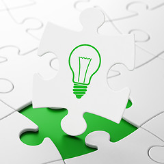 Image showing Finance concept: Light Bulb on puzzle background