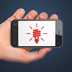 Image showing Finance concept: Energy Saving Lamp on smartphone