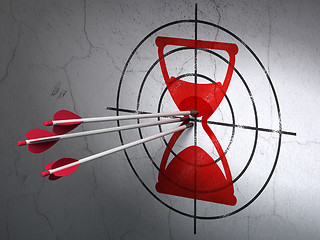 Image showing Time concept: arrows in Hourglass target on wall background