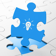 Image showing Finance concept: Light Bulb on puzzle background