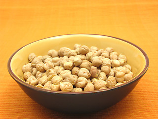 Image showing One bowl of ceramic with garbanzos on orange