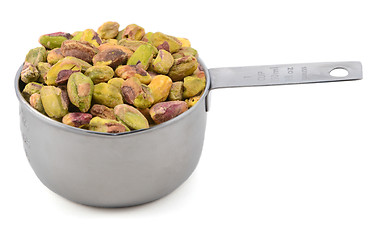 Image showing Shelled pistachio nuts in a metal cup measure