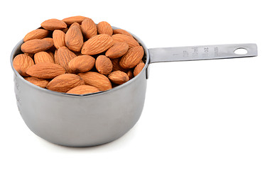 Image showing Whole unblanched almonds in a metal cup measure