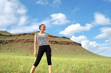 Image showing Woman in striped vest on a background of mountain herbs.