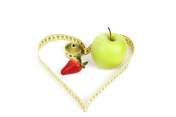 Image showing green apple with a measuring tape and heart symbol isolated