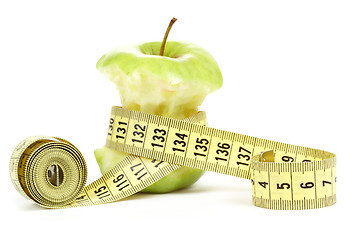 Image showing Green bitten apple isolated on white with measuring tape