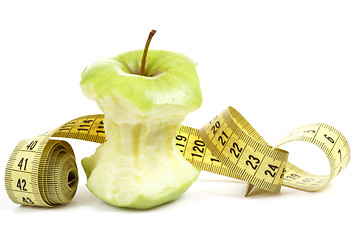 Image showing Green bitten apple isolated on white with measuring tape