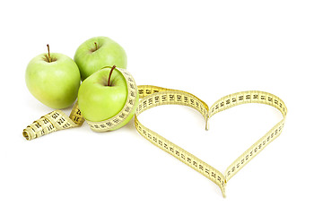 Image showing green apple with a measuring tape and heart symbol isolated