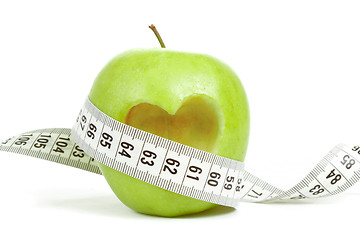 Image showing green apple with a measuring tape and heart symbol isolated