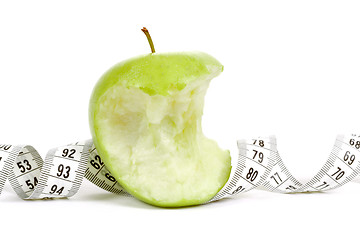 Image showing Green bitten apple isolated on white with measuring tape