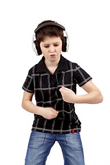 Image showing Portrait of a happy young boy listening to music and dancing
