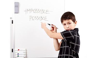 Image showing young boy student in a writing on a whiteboard